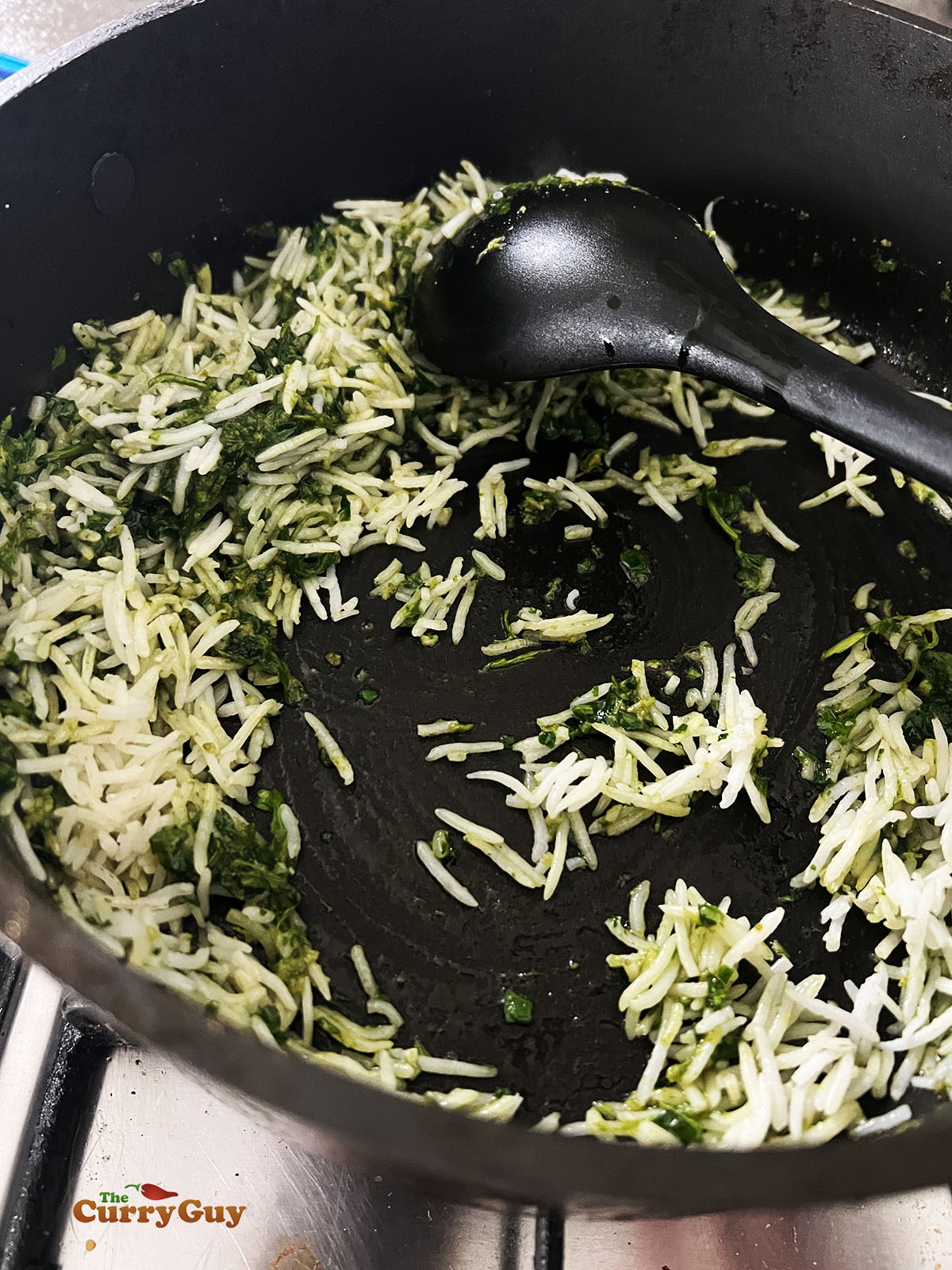 Adding rice to the green masala and ghee.