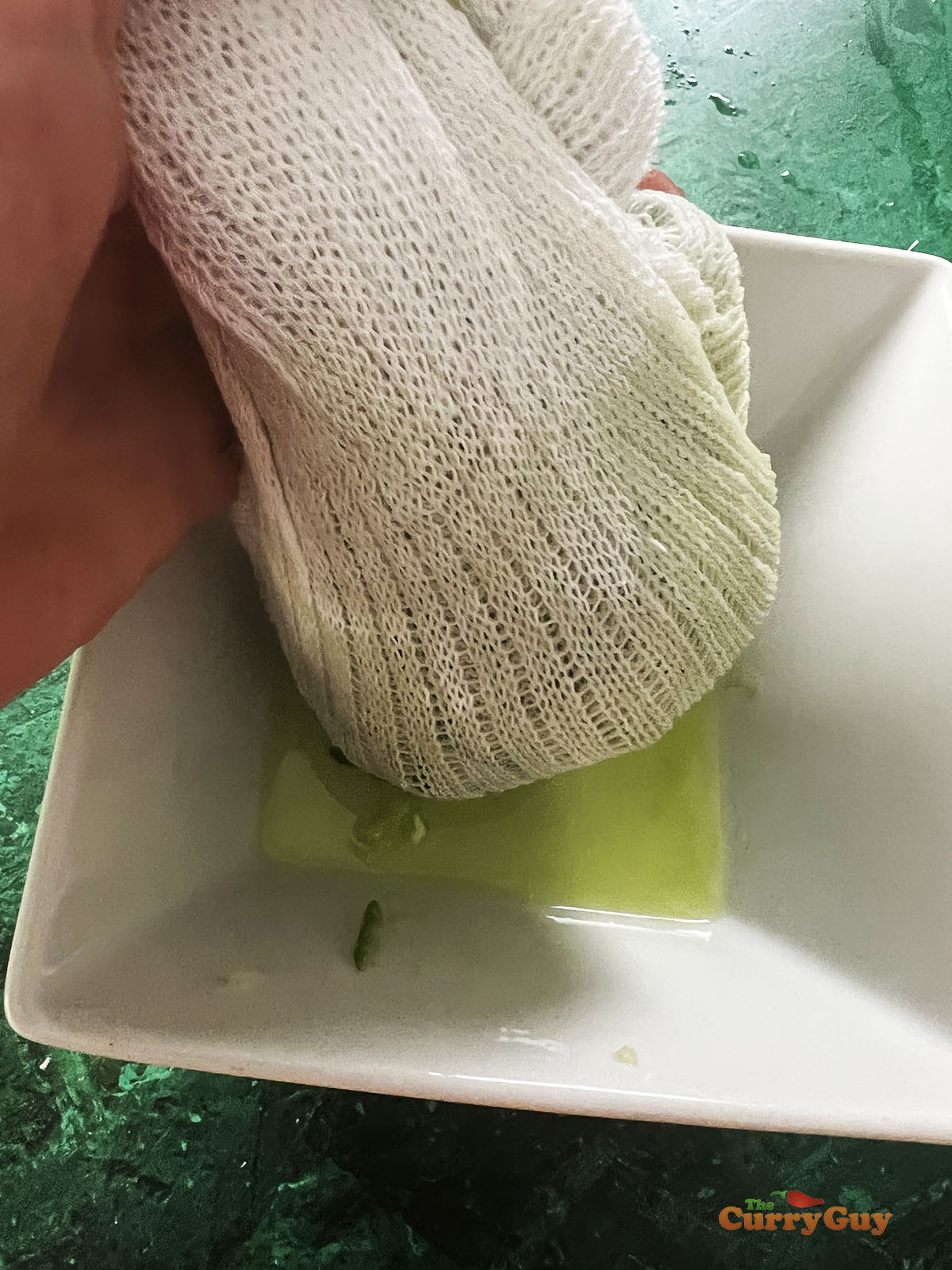 Squeezing the excess water out of the cucumber.