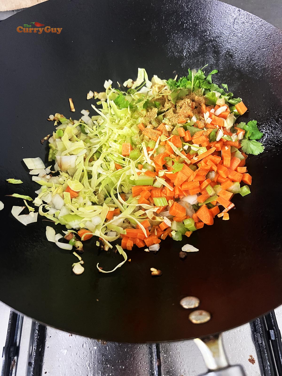 Adding the remaining vegetables to the wok.