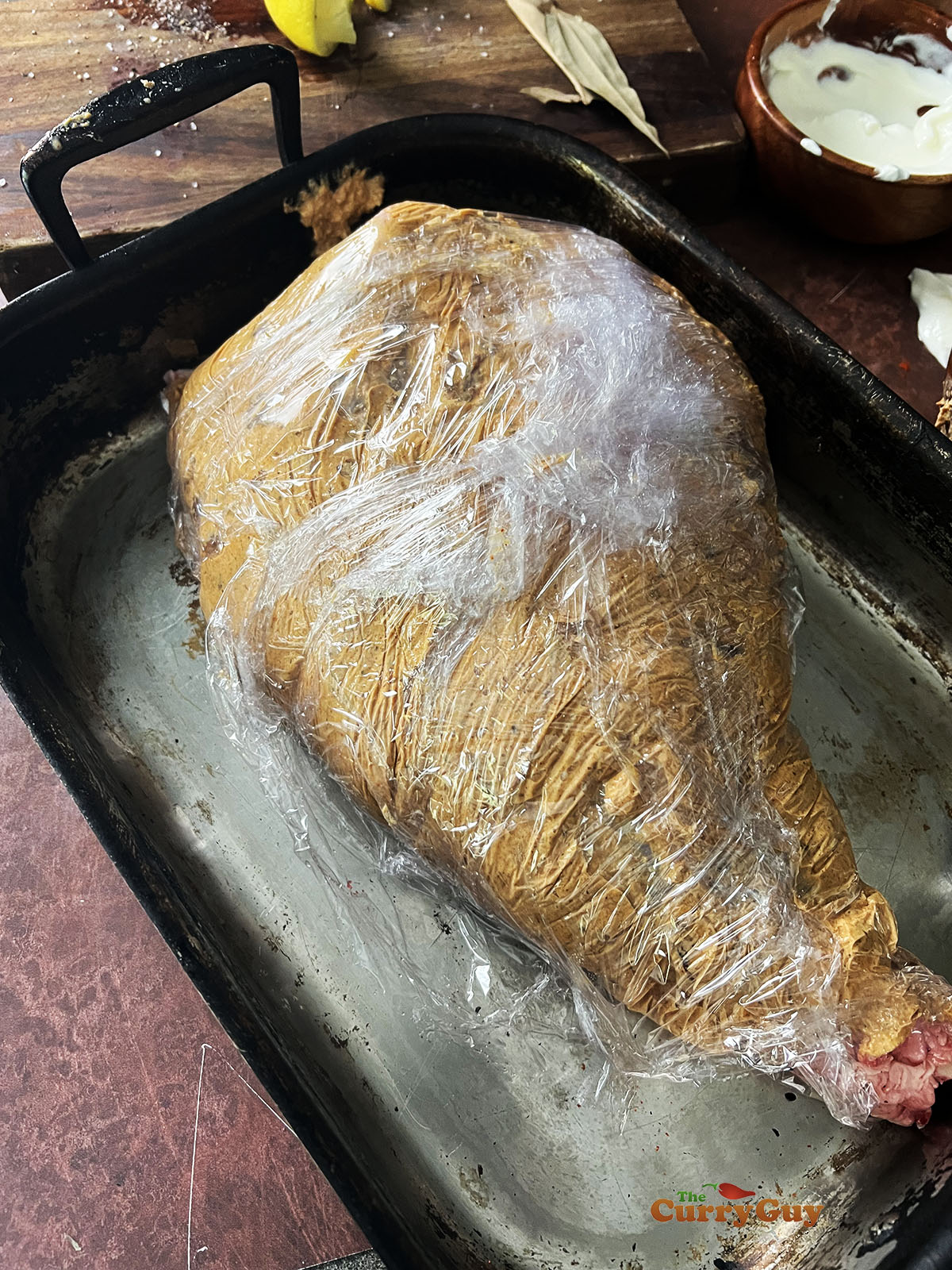 Lamb and it's marinade wrapped in cling film.