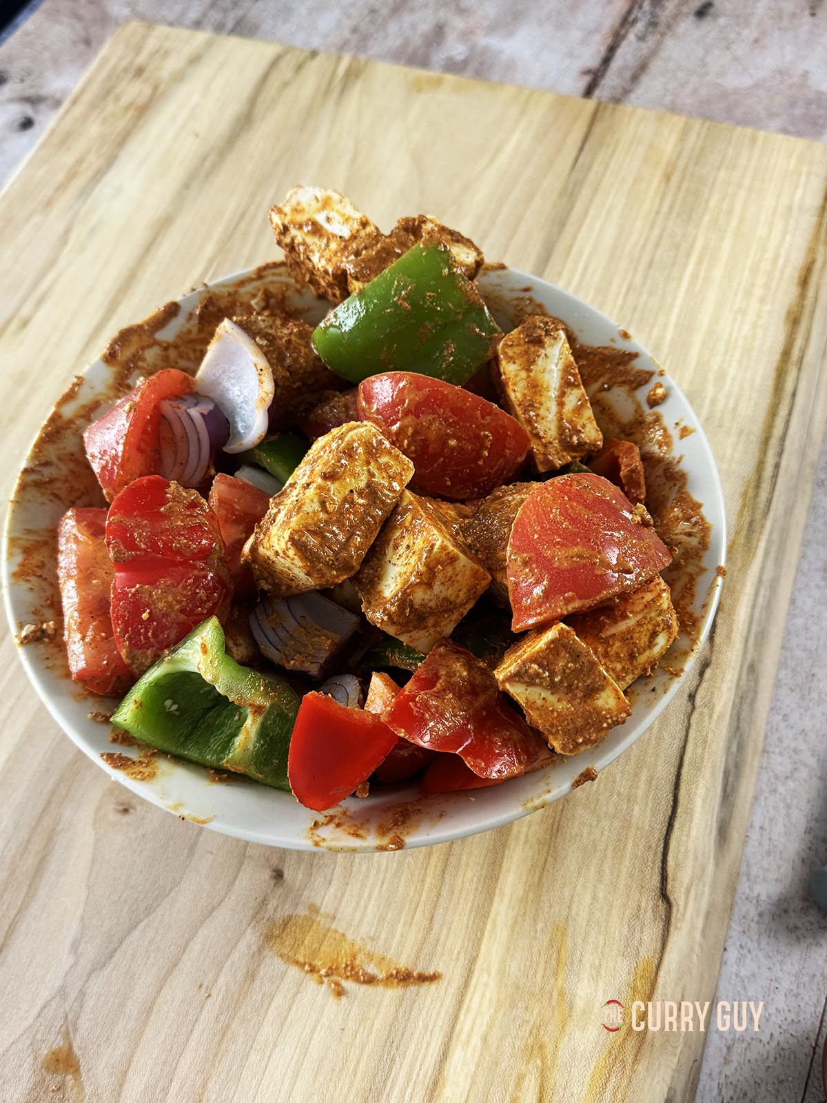 Paneer and vegetables marinating in a bowl.