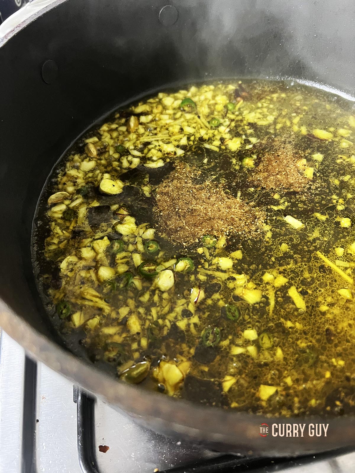 Adding garam masala to the pan.