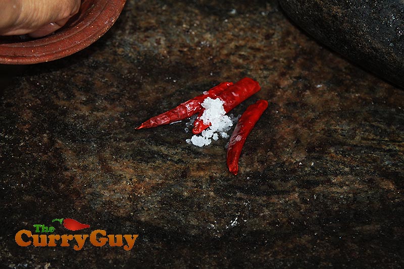 Making coconut, chilli and onion chutney