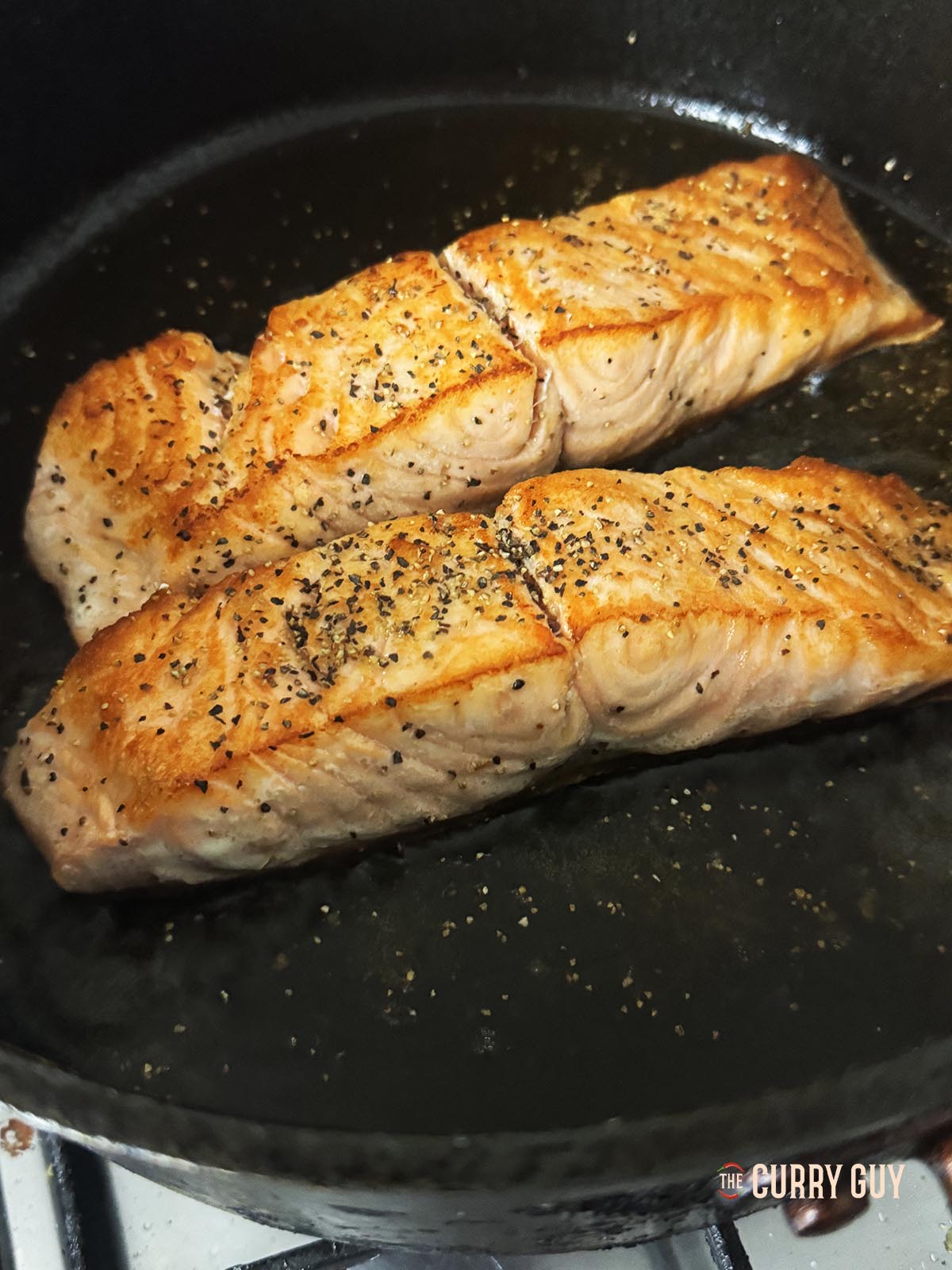 The salmon fillets, flipped over again with the skin side down.