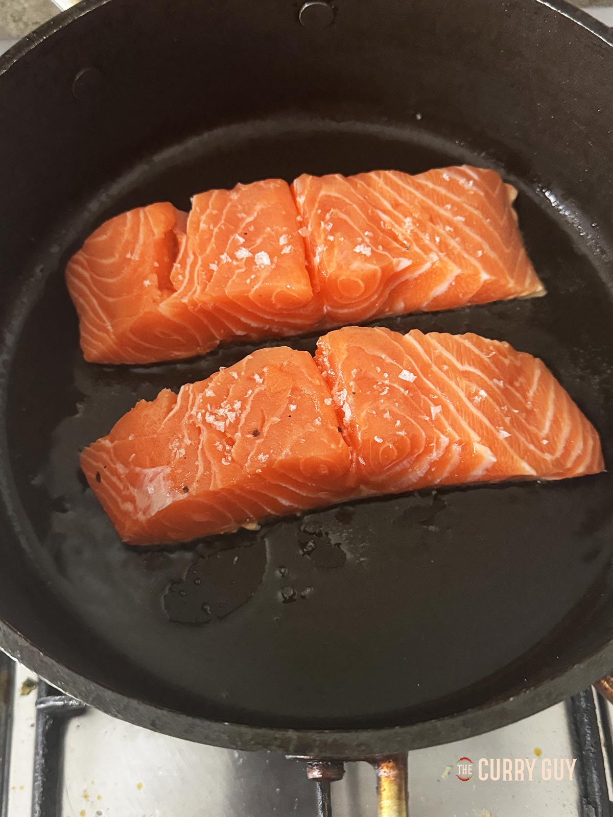 Frying the salmon fillets, skin side down in a hot pan.