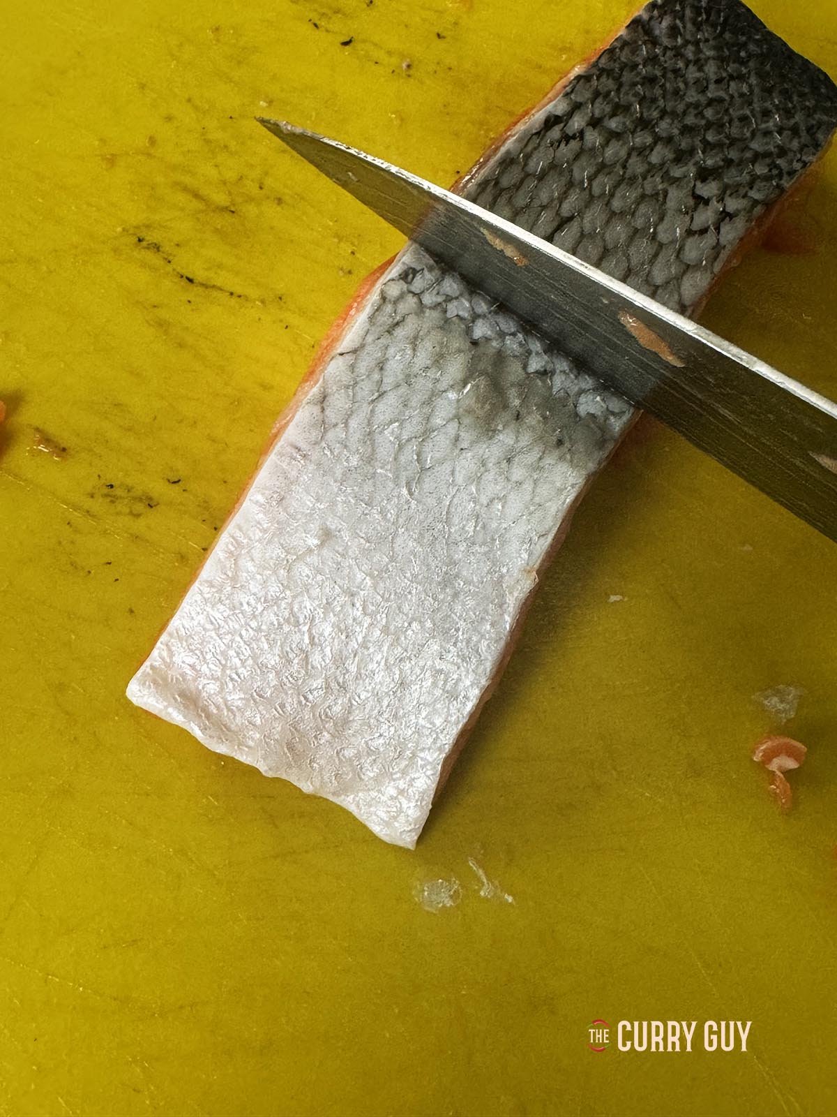 Scraping the moisture out of the salmon skin.