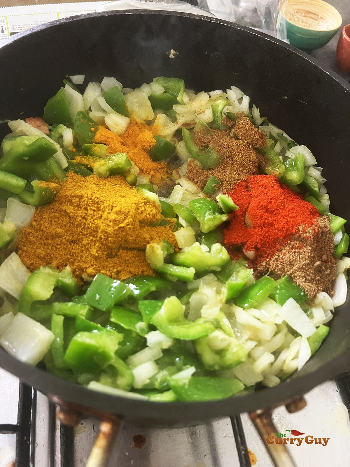 Adding ground spices to the shimla mirch.