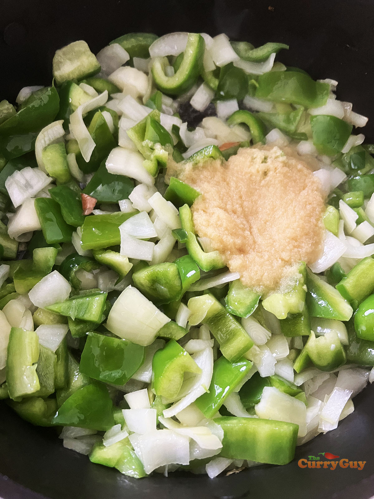 Adding garlic and ginger paste to the curry.