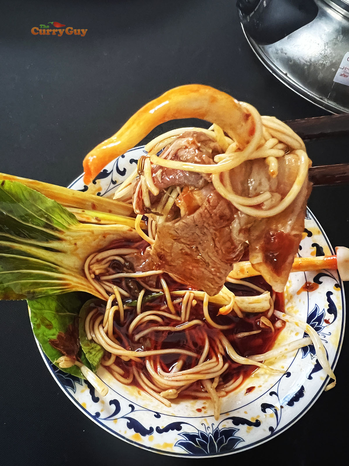 Eating the Chinese hot pot with spoon and chopsticks