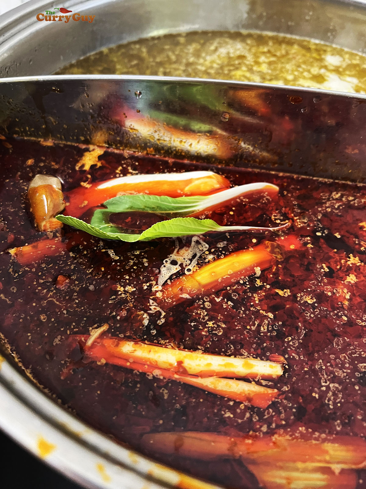 The hot pot broths prepared and heating at the table.