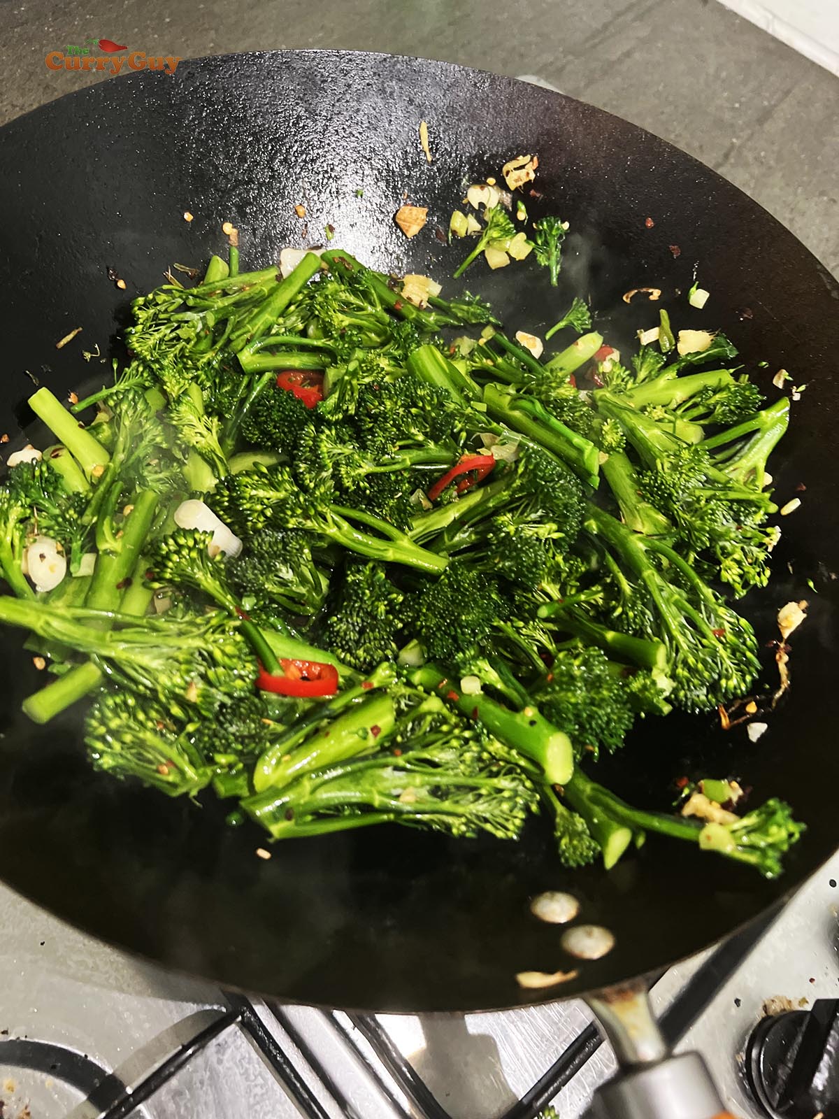 Adding the broccoli to the hot wok.