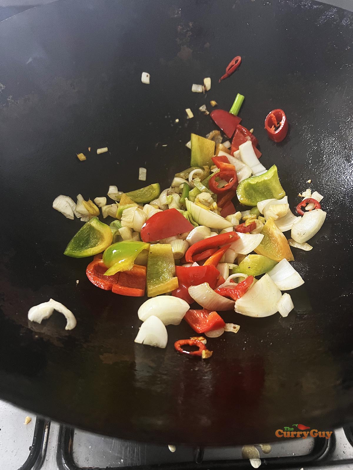 Frying onions and bell peppers with the aromatic ingredients.