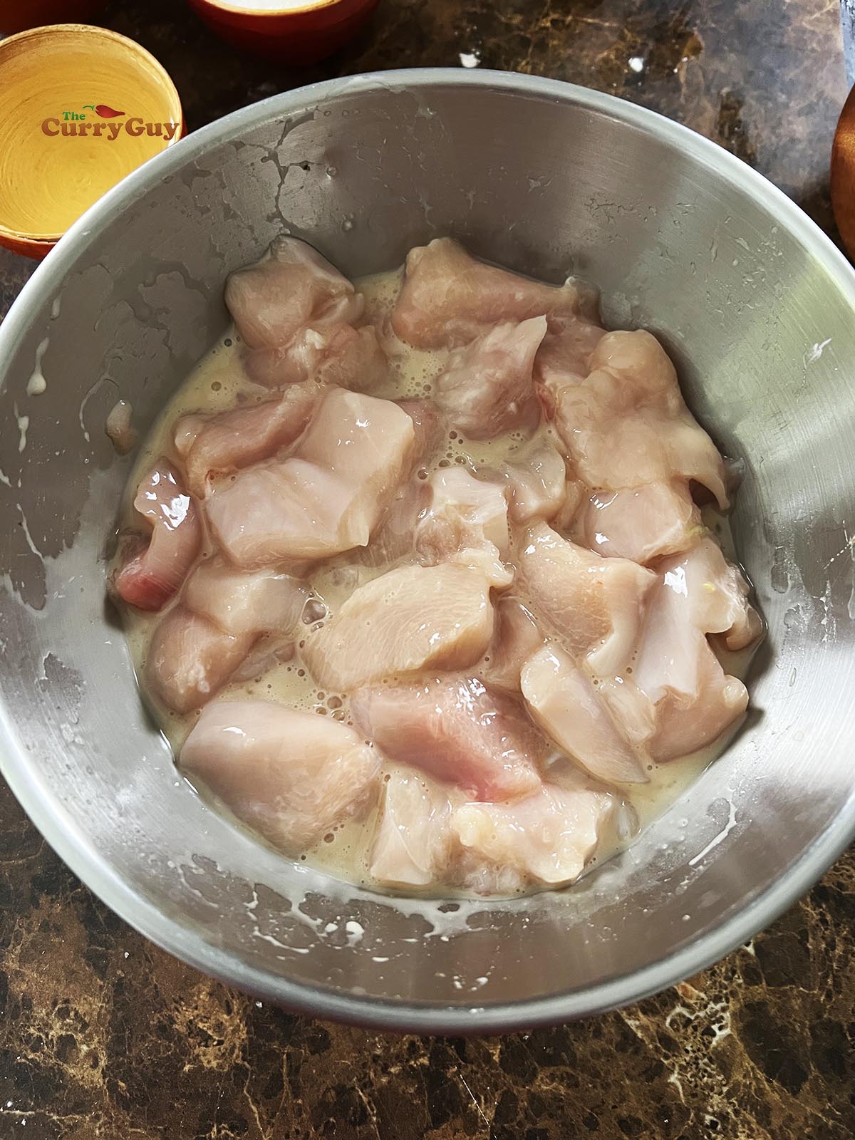 Chicken marinating in a bowl. 