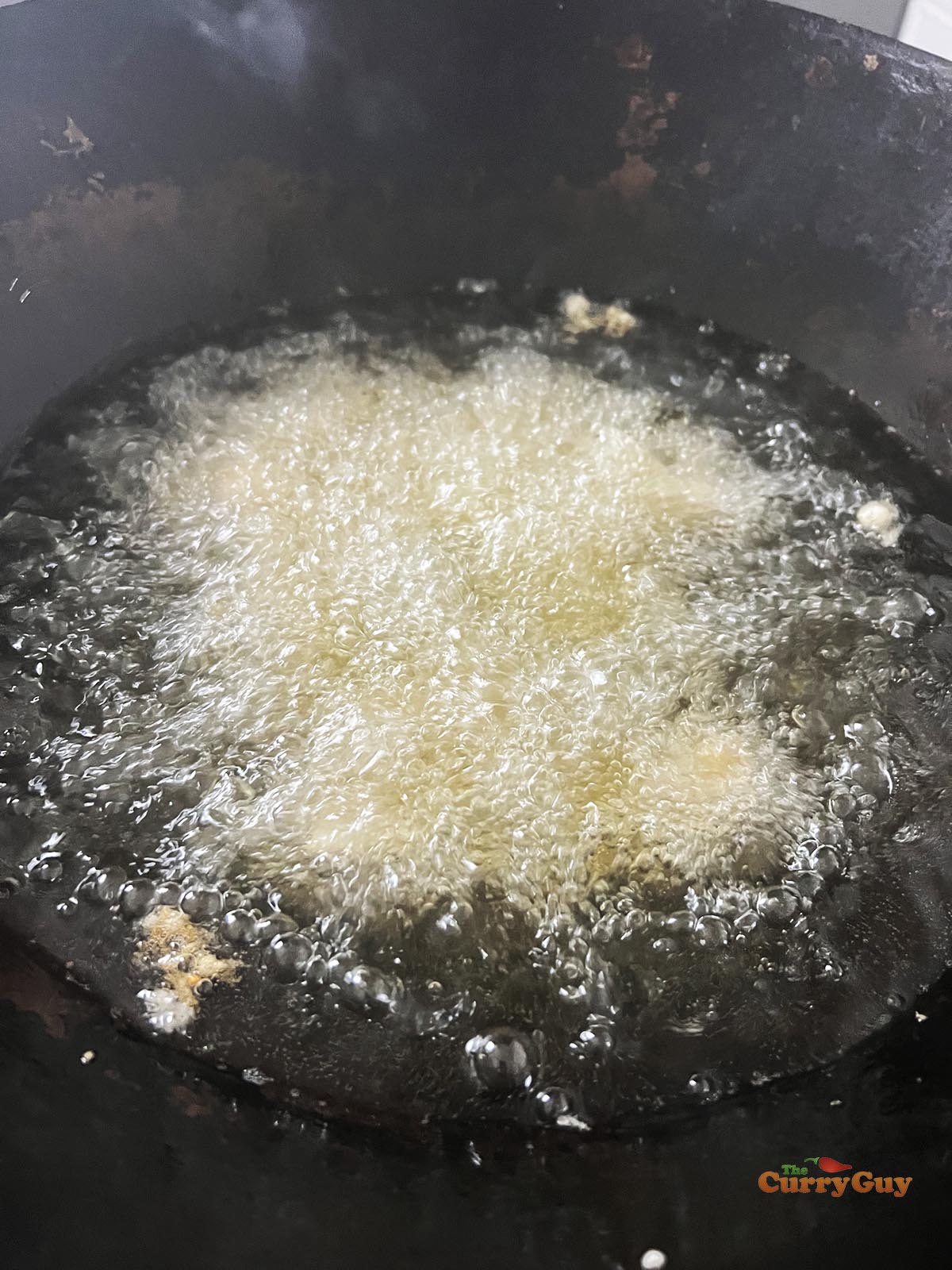 Frying the marinated chicken.