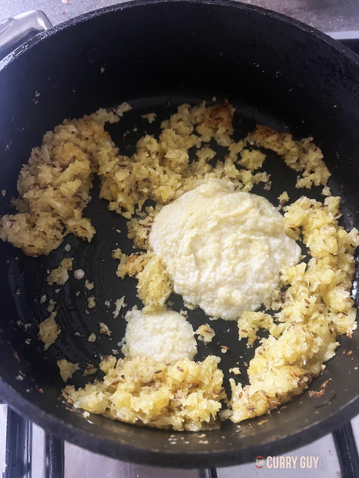 Adding garlic and ginger paste to the pan.
