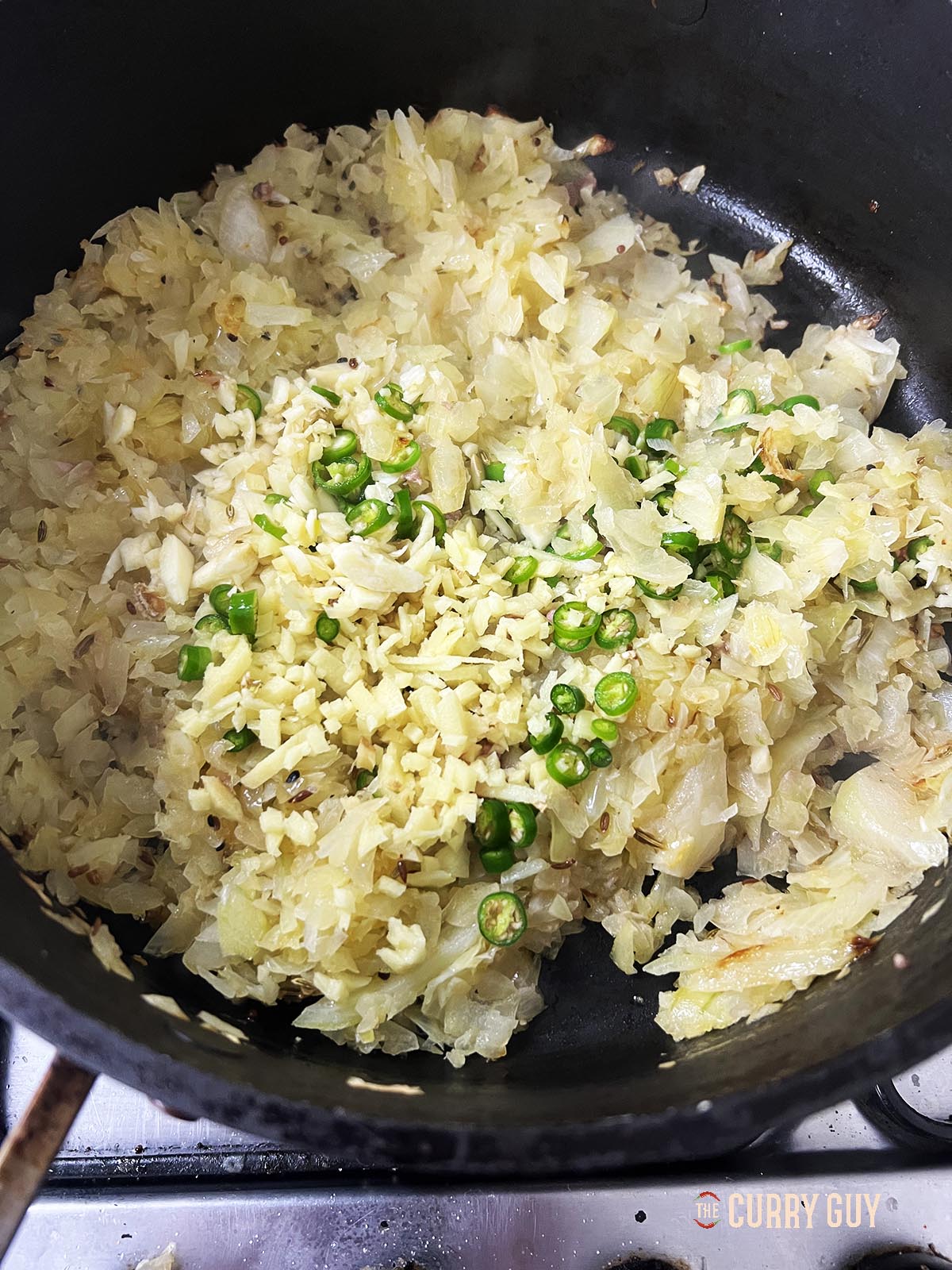Adding onions, garlic, chillies and ginger to the pan.