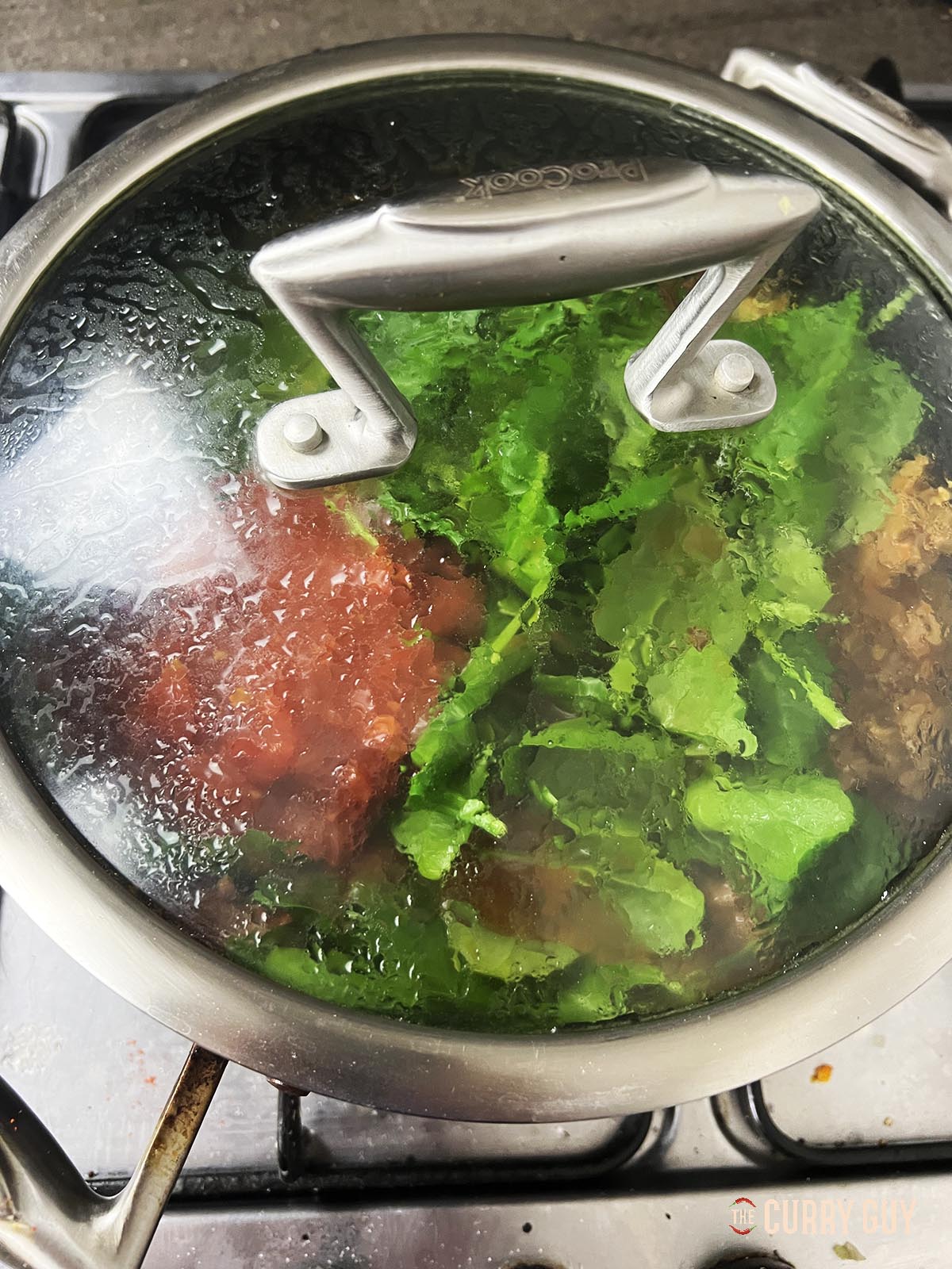 Adding spinach and chopped tomatoes to the pan.