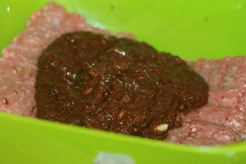 Adding vindaloo marinade to pork mince