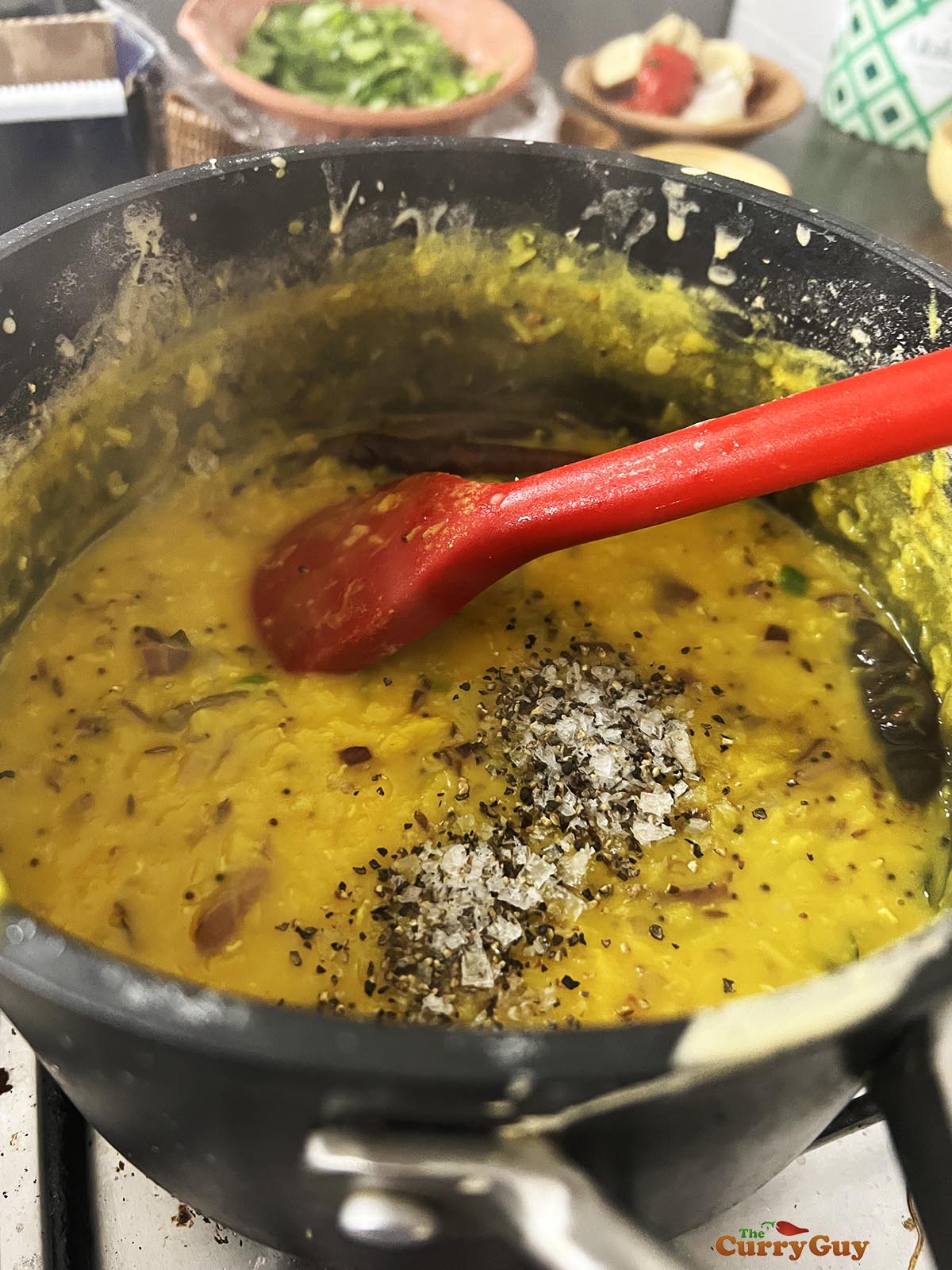 Stirring the tarka into the lentils and adding salt and pepper to taste.