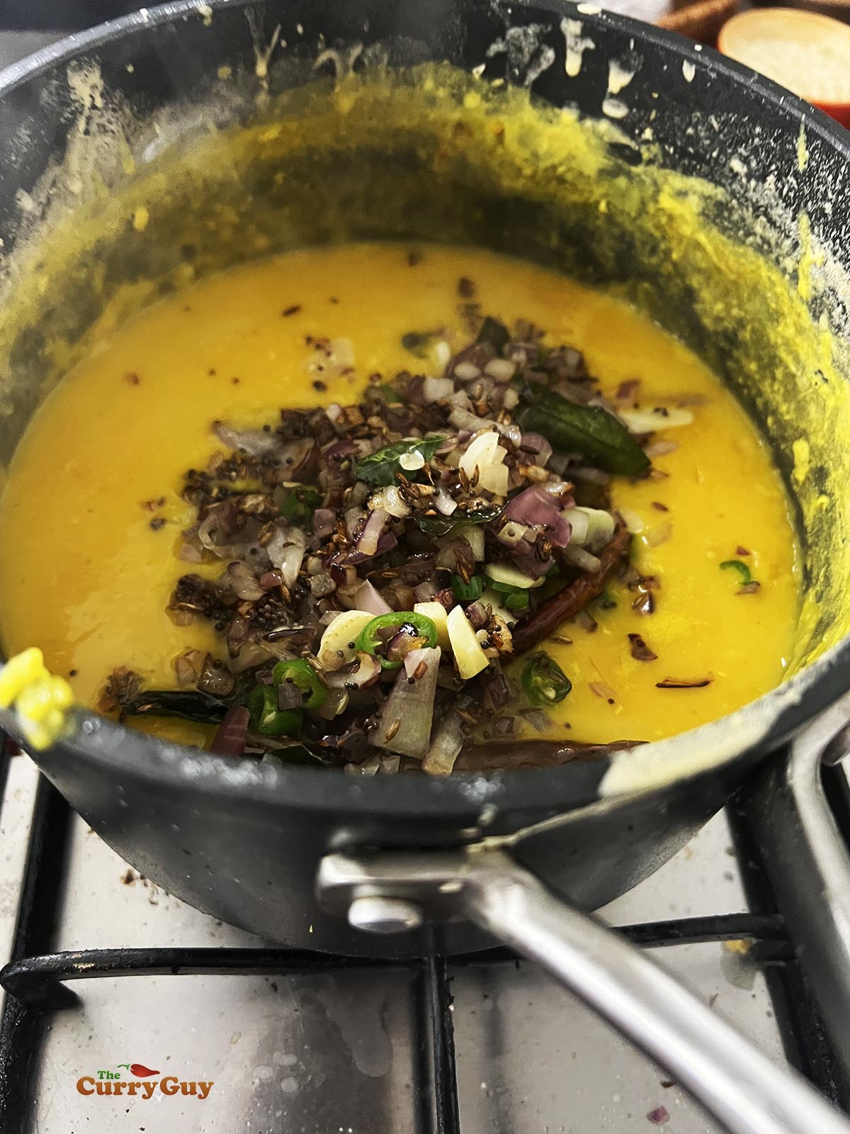Adding the tarka to the cooked masoor lentils