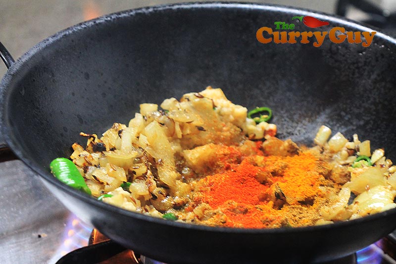 Making aubergine balti