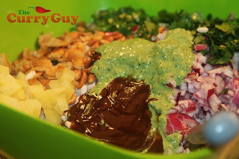 Adding the liquid ingredient and other crunchy bits like papdi and bombay mix.