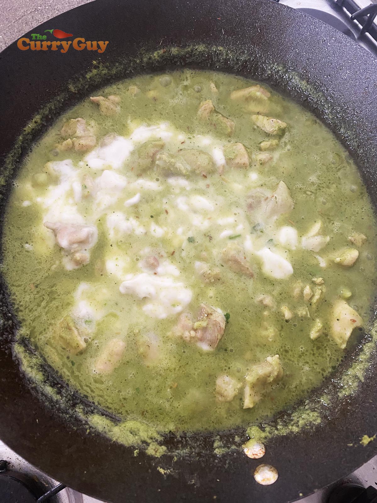 Stirring coconut milk into the green curry sauce.