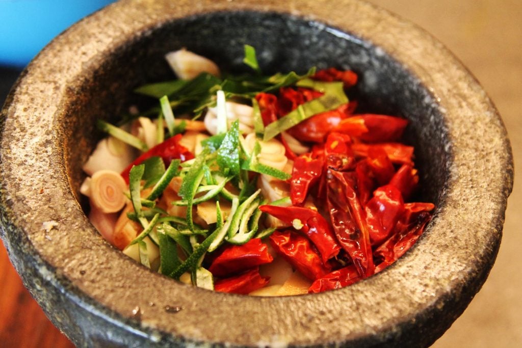 All of the paste ingredients in a pestle and mortar.