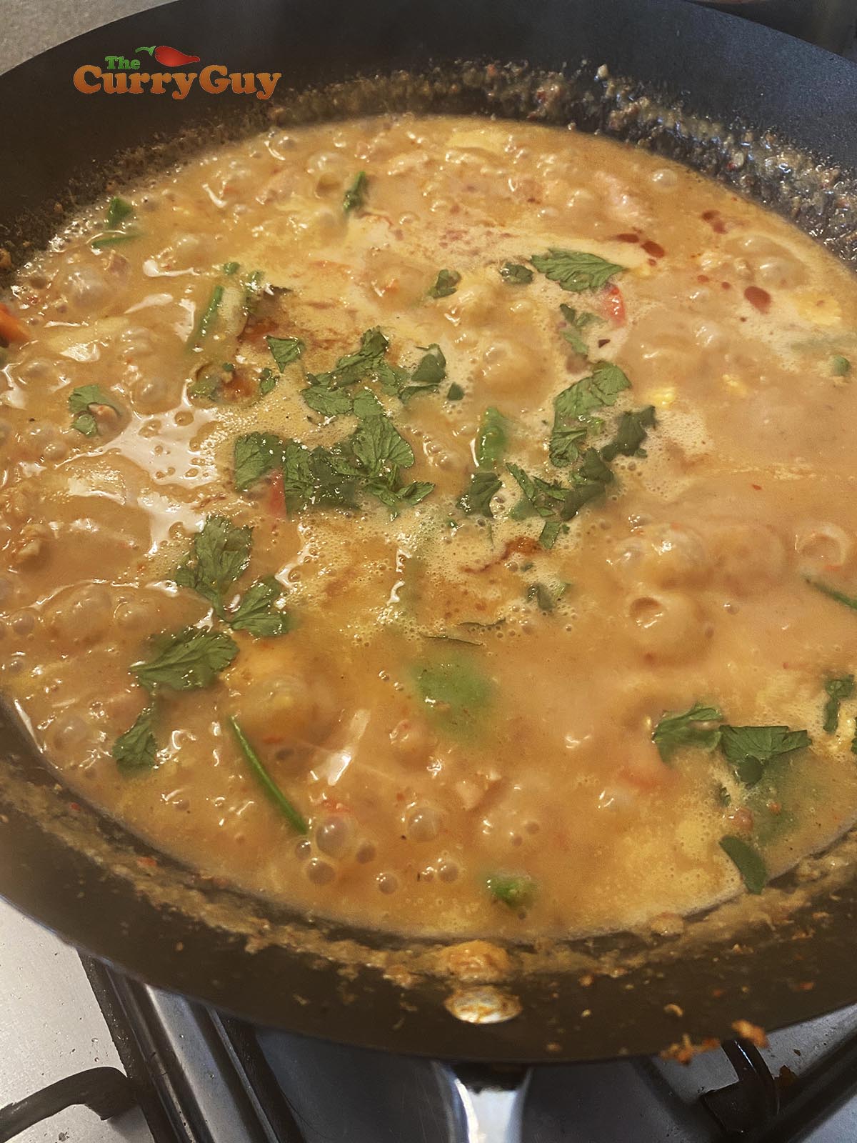 Adding vegetables to the curry.