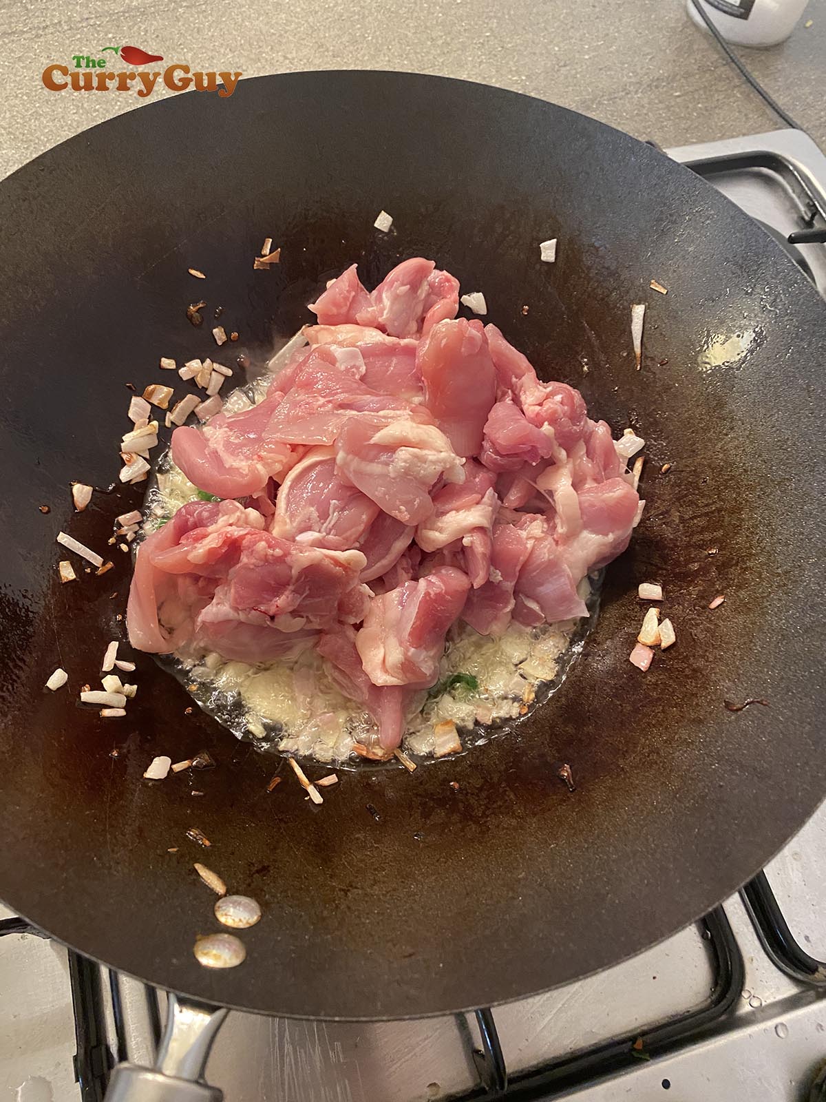 Adding chicken to wok