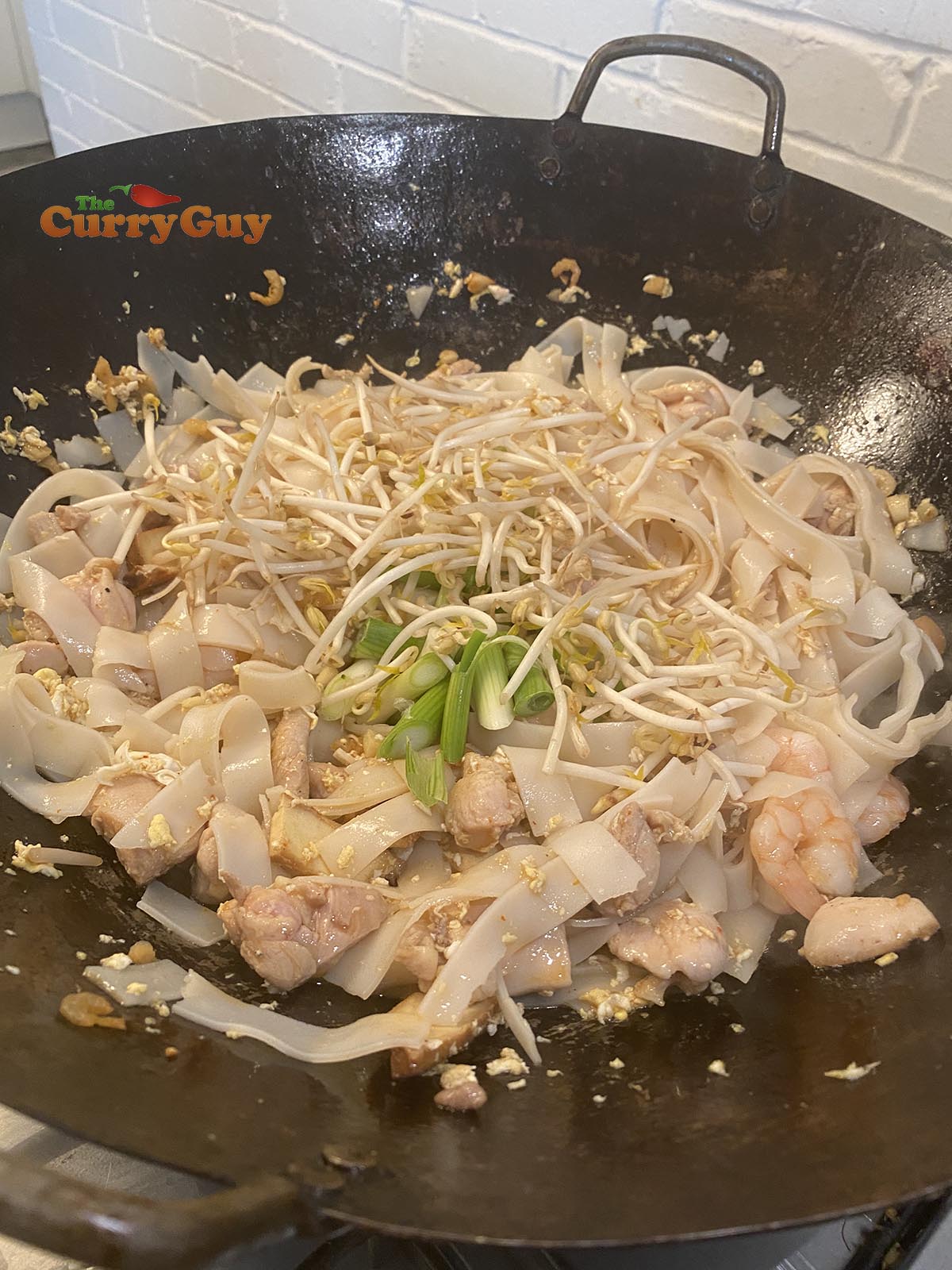 Adding spring onions and sprouts.