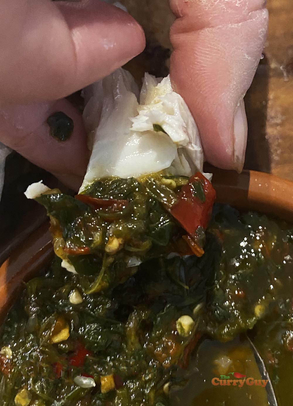 Dipping fish into the Thai seafood sauce.