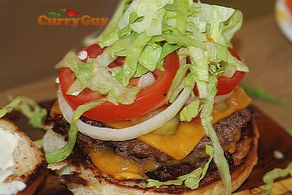 Adding lettuce to a cheeseburger