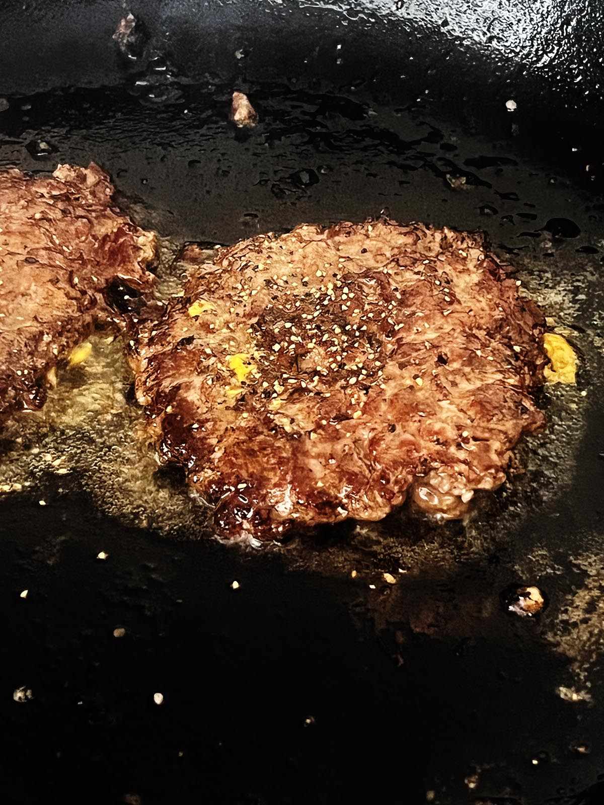 Seasoning the meat patties.