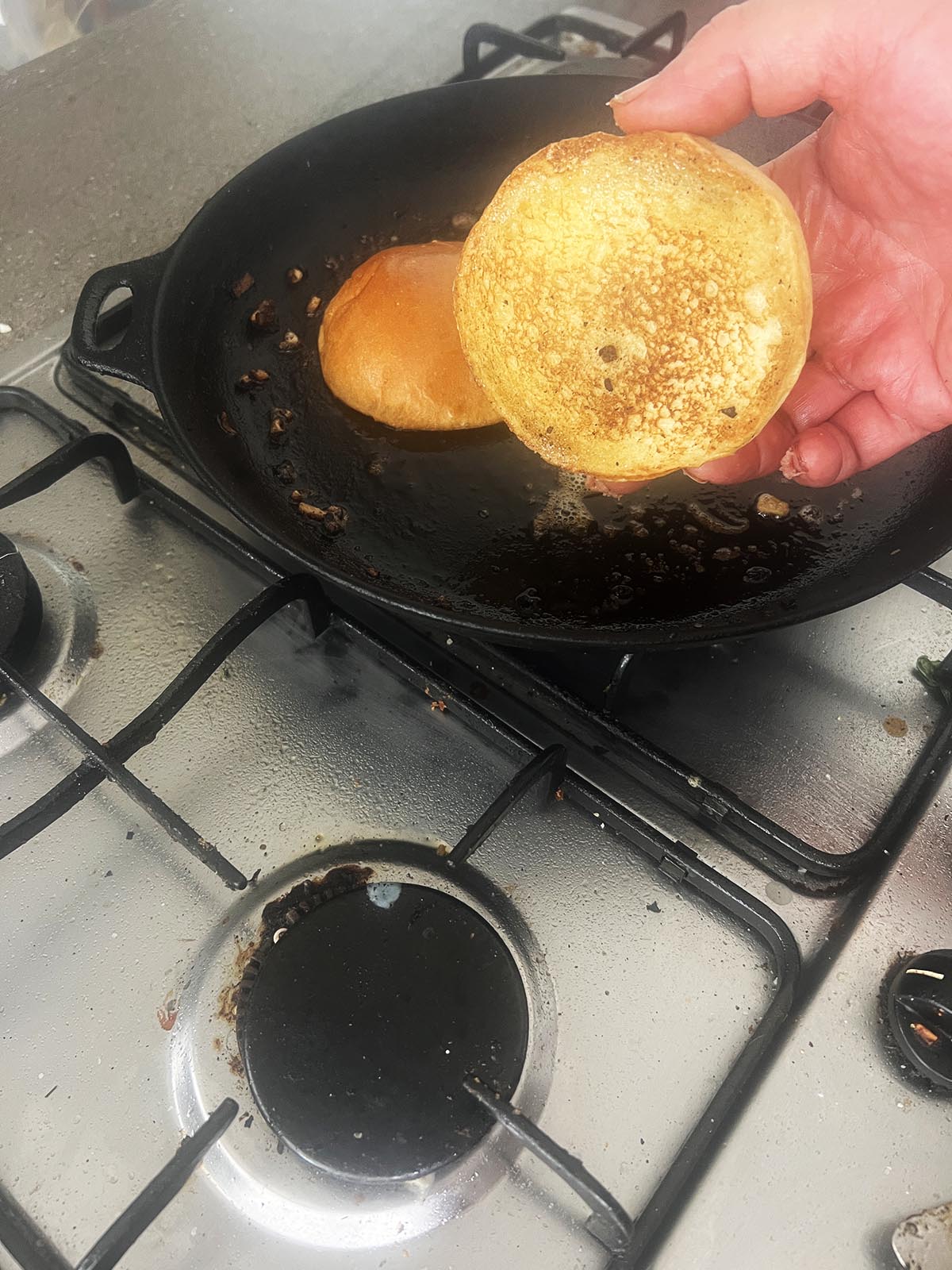 Toasting the buns in butter until golden brown.
