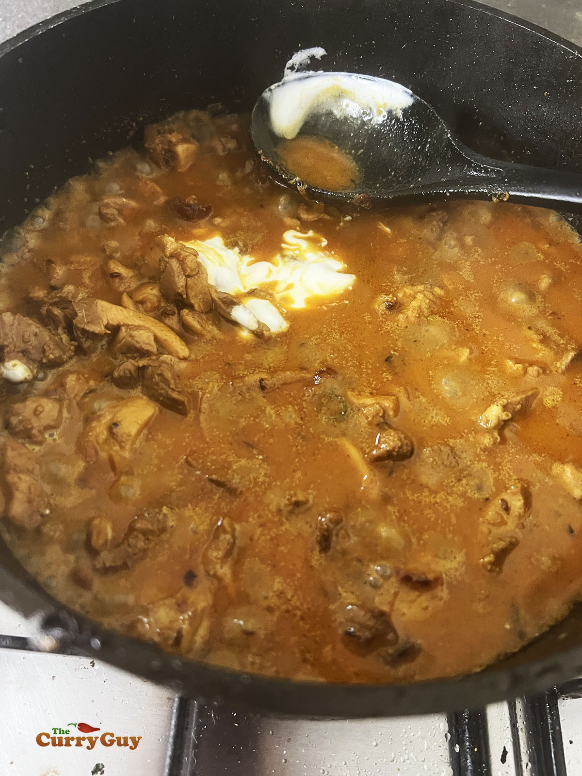 Adding yoghurt to the pan.