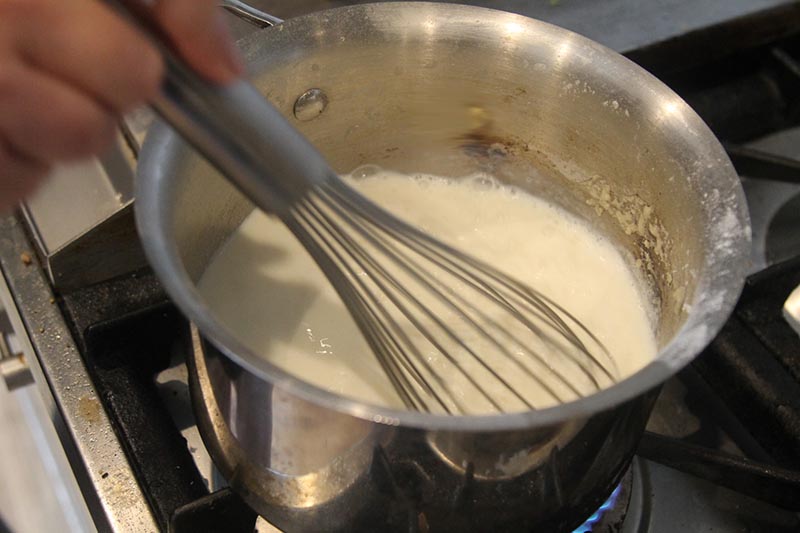 Add milk to the roux