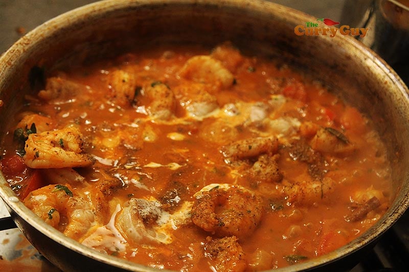 Adding hers and lemon to prawn curry