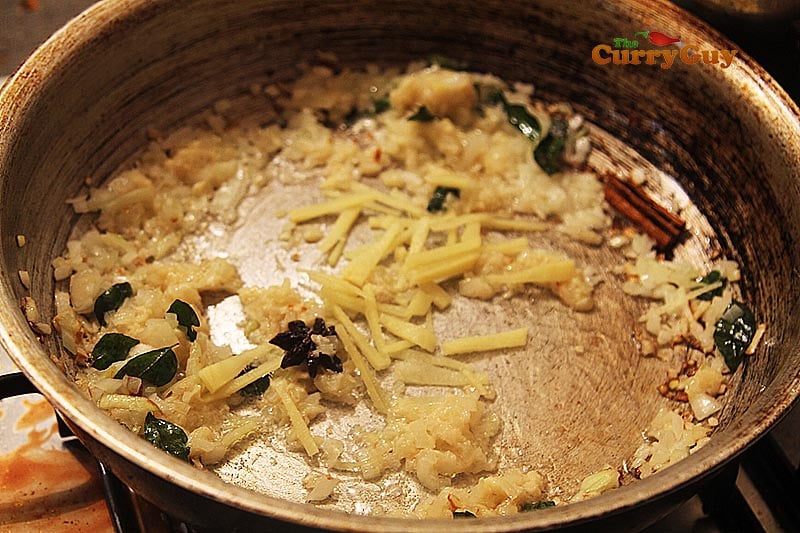 Stirring garlic and ginger to make prawn sauce