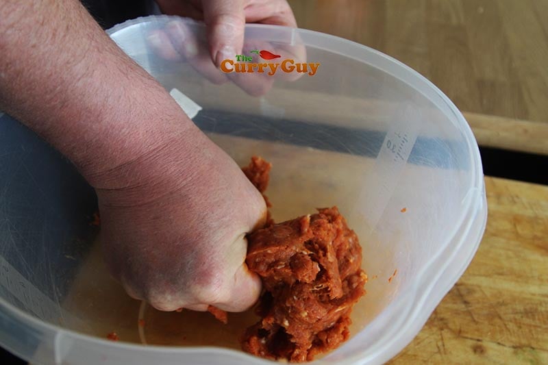 Mixing the curry paste into the meat.