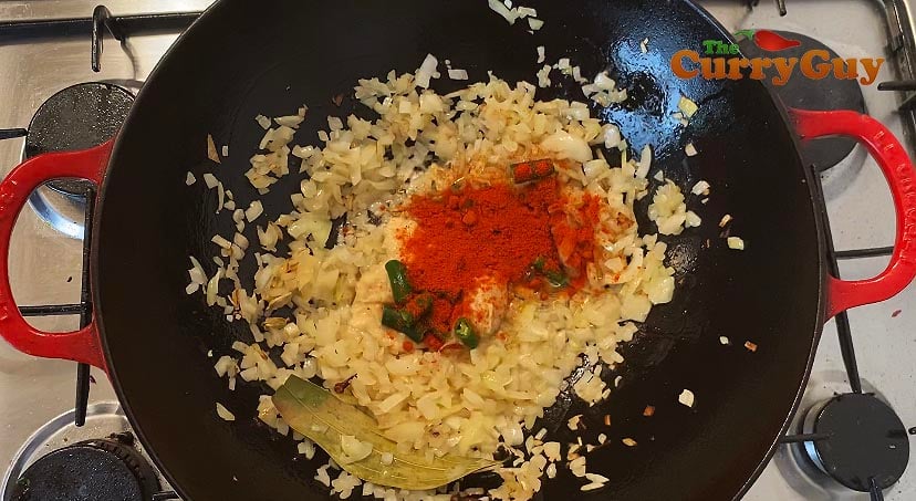 Stirring ground spices into muttar paneer sauce.