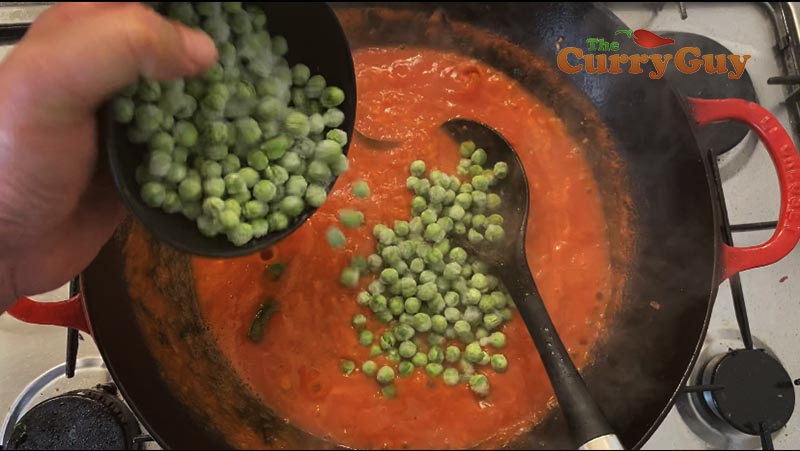 Adding peas to sauce.