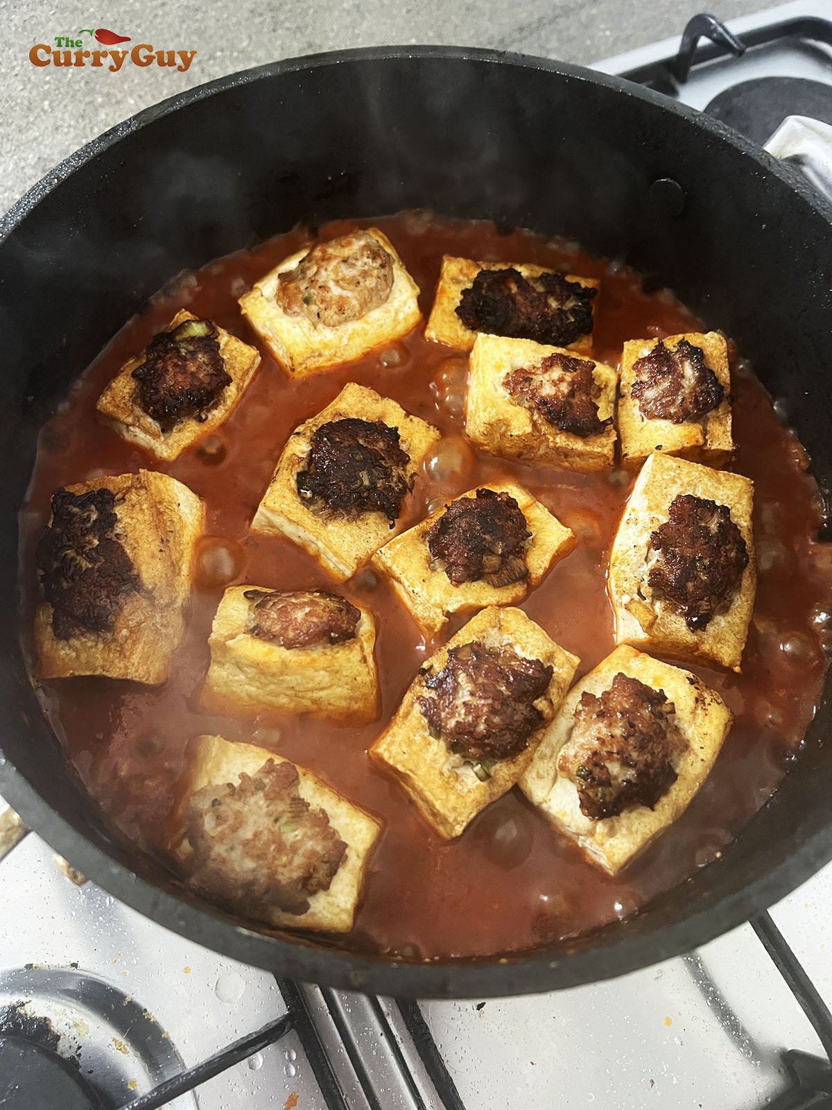 Returning the pork stuffed tofu to the sauce.