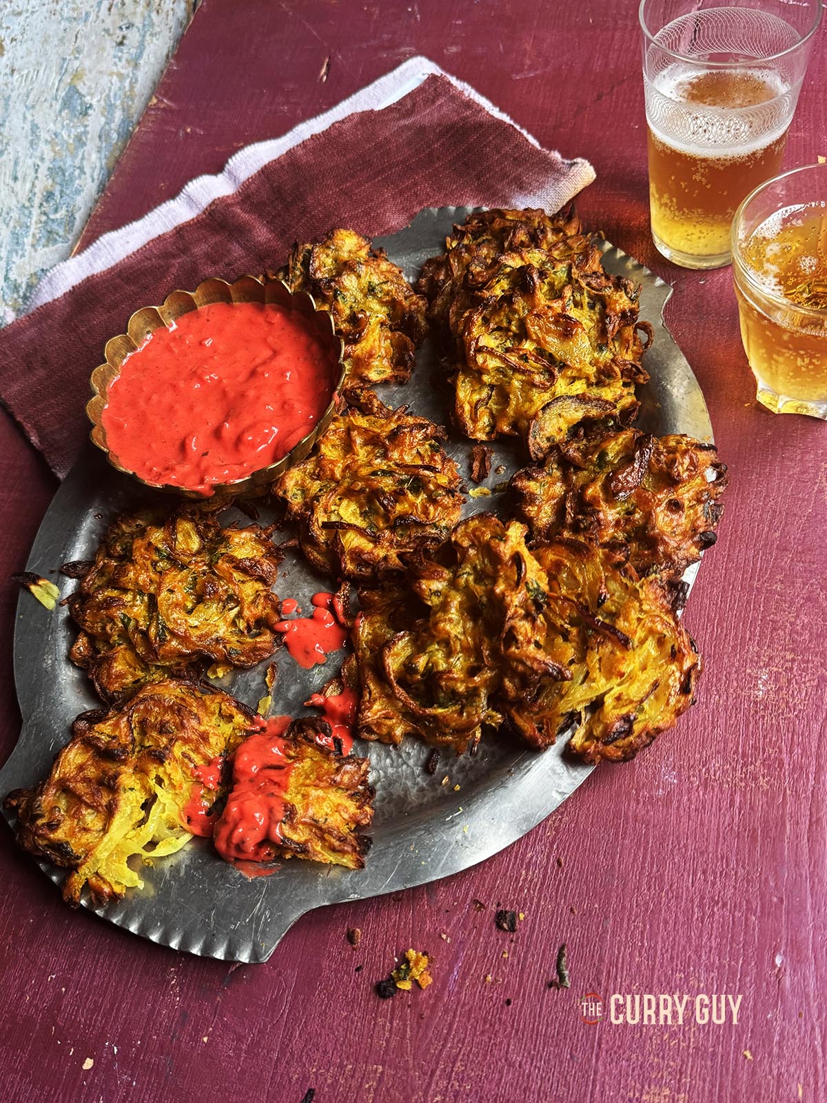 Air fryer onion bhajis on a serving platter with pakora dip.