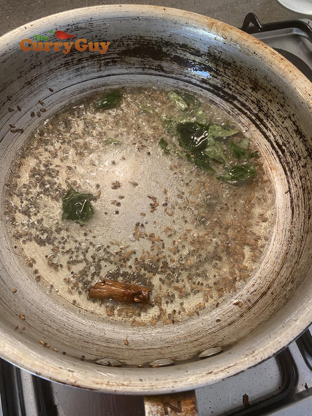 adding cinnamon, cumin, fenugreek and curry leaves