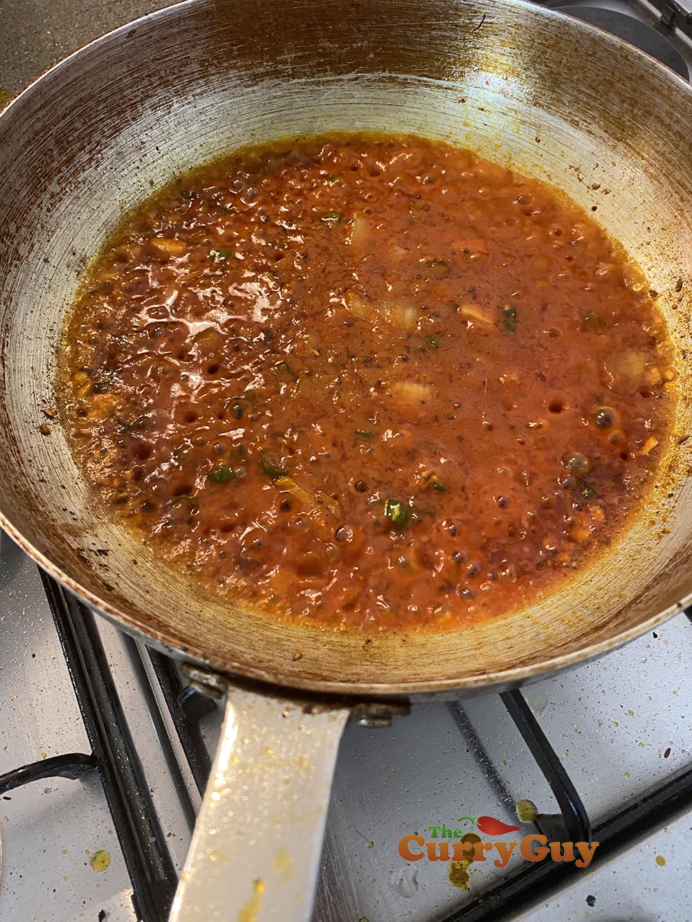 Stirring in the tomato puree and spices.