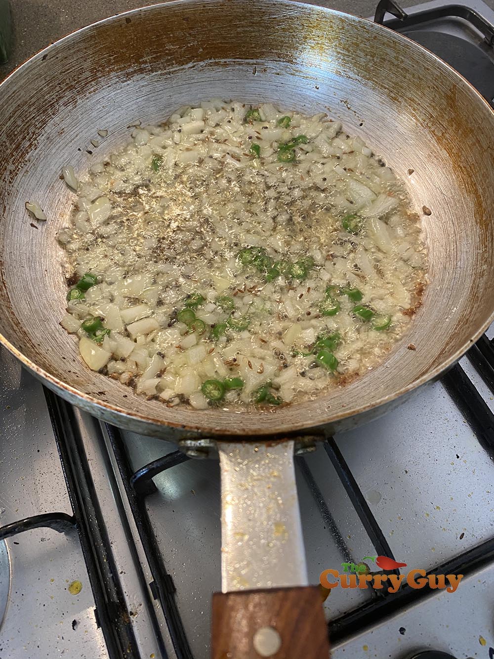 adding cumin seeds, onion and chillies.
