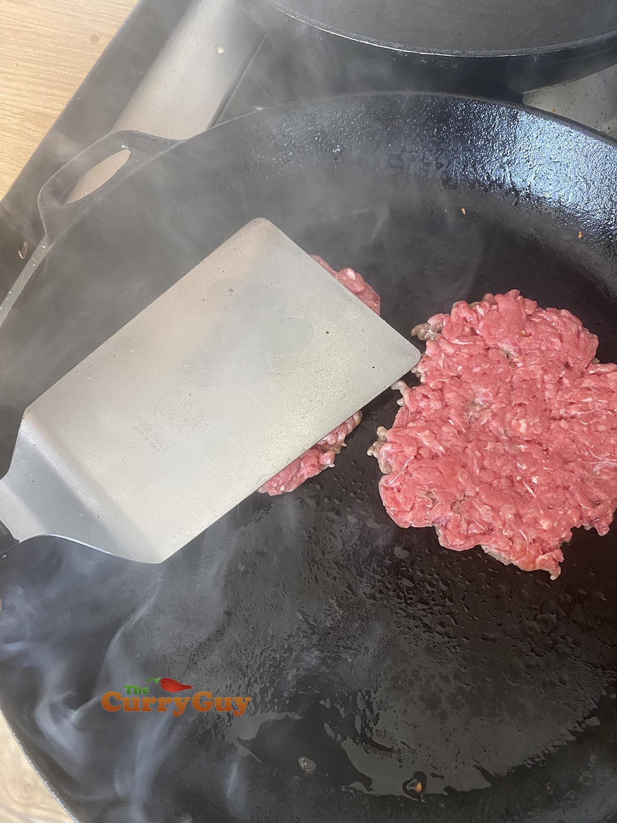 smashing the beef balls in the pan