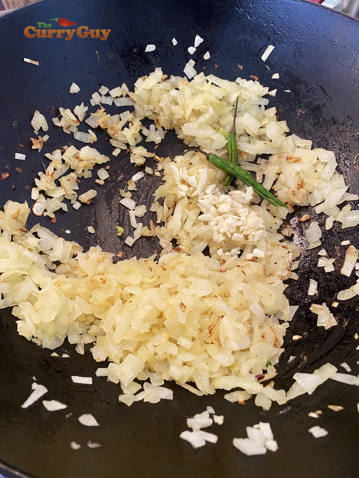 Adding garlic and chillies to the currywurst