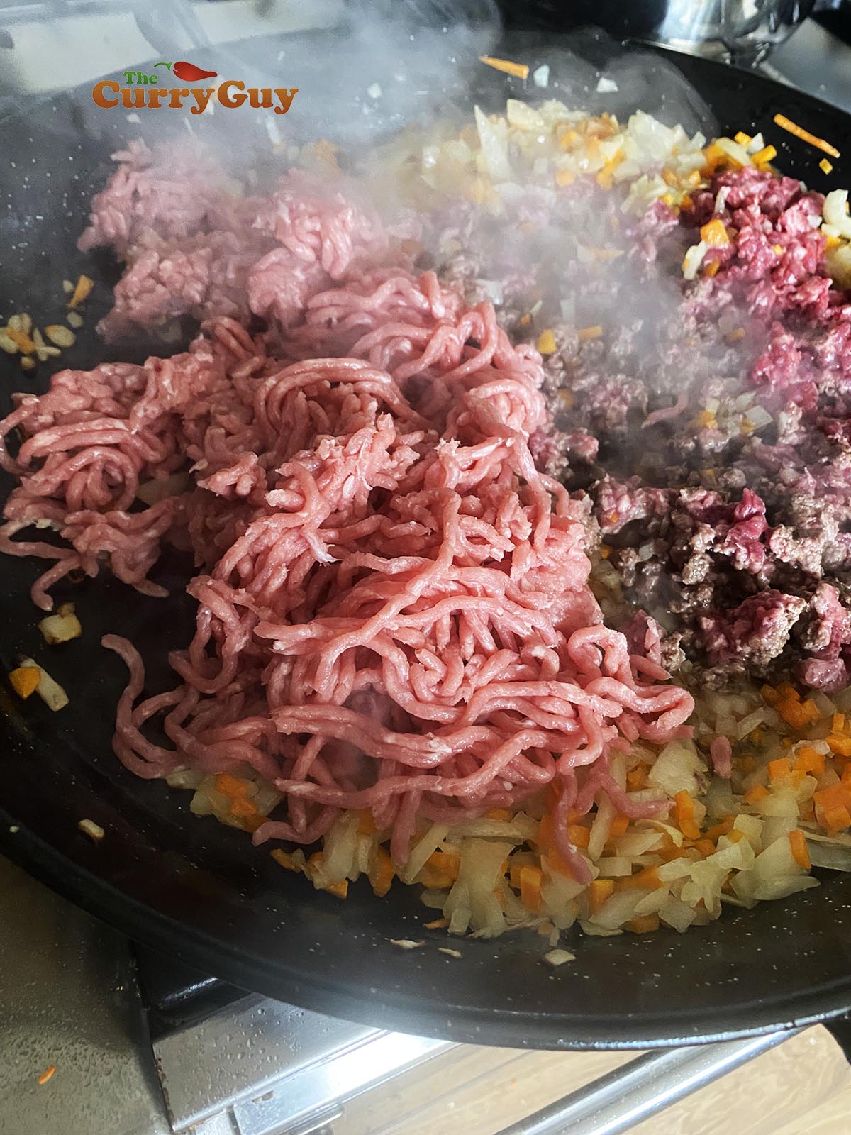 Adding chopped garlic and beef to the pan.